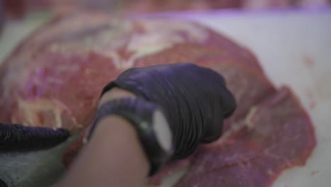 Butcher-cuts-pieces-of-beef-with-knife-in-supermarket