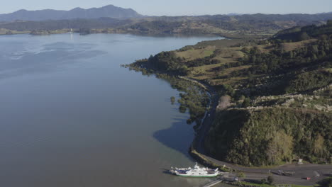 Aerial-drone-shot-of-the-Hokianga-Vehicle-Ferry-going-to-Rawene,-North-Island,-New-Zealand