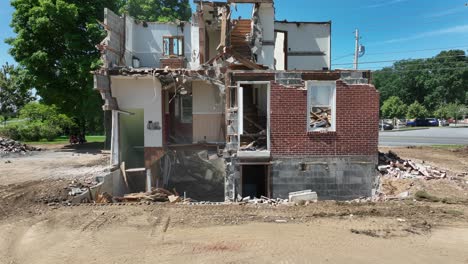 Aerial-rising-shot-of-condemned-home-being-torn-down