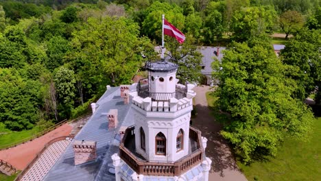 Waving-Flag-Over-Tower-Of-The-Neo-Gothic-Sigulda-New-Castle-In-Sigulda,-Latvia