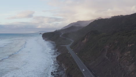 Un-Coche-Circula-Por-La-Autopista-En-La-Costa-Oeste-De-La-Isla-Sur-De-Nueva-Zelanda