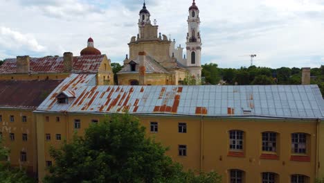 Aerial-Rising-Shot-showcasing-aged,-rustic-buildings-including-a-centrally-featured-church-with-a-clock-tower