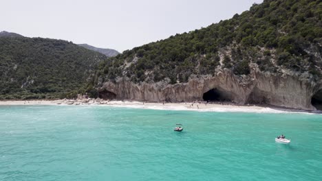 Menschen-Schwimmen-Und-Boote-Im-Türkisfarbenen-Wasser-In-Cala-Gonone-In-Sardinien,-Italien