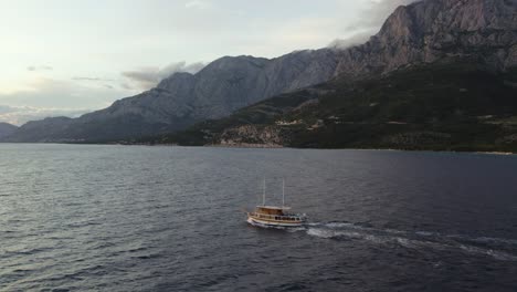 Toma-Aérea-De-Seguimiento-De-Un-Barco-En-El-Mar-Adriático-En-La-Costa-De-Makarska-En-Croacia