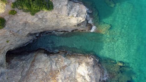 Un-Dron-Vuela-A-Vista-De-Pájaro-Sobre-El-Mar-En-La-Bahía-De-Evita,-Bali,-En-Creta,-Grecia.-El-Mar-Es-Azul-Y-Claro,-Una-Hermosa-Bahía-Con-Playa.