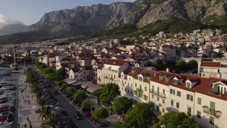 Scenic-aerial-of-Makarska-town-near-Adriatic-sea-with-yacht-dock,-Croatia