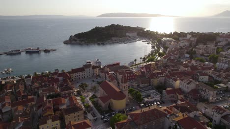 Aerial---Makarska-town-red-clay-tile-rooftops-during-golden-hour,-Croatia