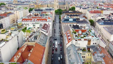 Aerial-tilt-up-establishes-side-view-of-Votivkirche-churchl-in-Vienna-Austria-with-road-leading-to-garden-grounds