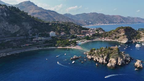 Beautiful-aerial-view-of-Isola-Bella-in-Sicily-surrounded-by-clear-blue-water-and-boats