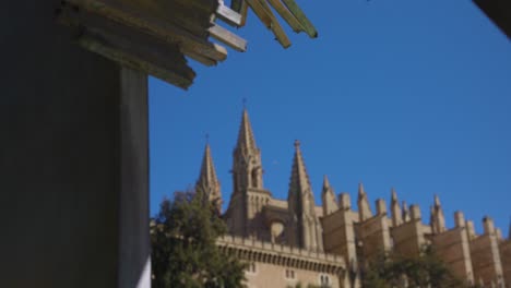 Tilt-down-reveal-of-stunning-cathedral-in-Palma-de-Mallorca-against-blue-sky