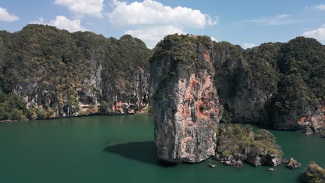 Pan-done-shot-of-giant-rock-standing-on-sea-in-Pai-Plong-Beach-during-daytime-in-Krabi,-Thailand