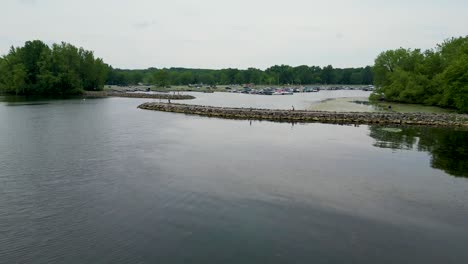 Peaceful-marina-scene-with-boats-docked,-surrounded-by-greenery-and-calm-waters,-ideal-for-showcasing-leisure-and-nautical-themes