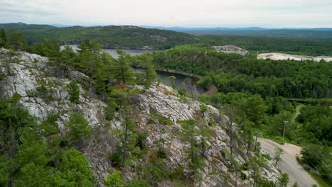 Aerial-fly-through-forest-trees-to-reveal-lake