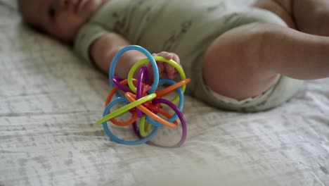 Baby-Caucasian-boy-playing-with-a-colorful-toy-on-a-play-mat