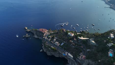 A-coastal-town-with-boats-and-clear-blue-water-during-the-day,-aerial-view