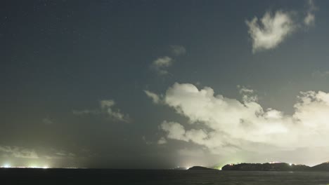 Timelapse-view-of-white,-smoky-clouds-passing-over-green-lands-during-evening