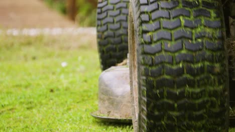 Panning-Shot-of-Ride-On-LawnMower-from-behind-with-Grass-Cuttings-Ejecting-in-Slow-Motion