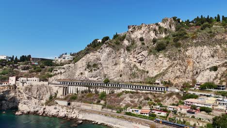 Eine-Küstenbahnstrecke-Verläuft-Entlang-Einer-Felsigen-Klippe-Mit-Türkisfarbenem-Wasser-Darunter