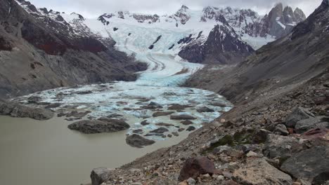 Panoramic-view-of-Patagonian-glacier-cascading-into-the-frozen-waters-of-Cerro-Torre-Lake