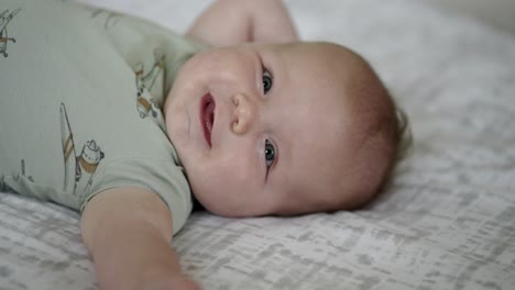 Baby-Caucasian-boy-playing-with-a-colorful-toy-on-a-white-play-mat