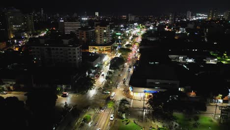 Vuelo-Elevado-Sobre-El-Tráfico-De-Las-Calles-De-La-Ciudad-Iluminadas-De-Noche-En-Santa-Cruz,-Bolivia