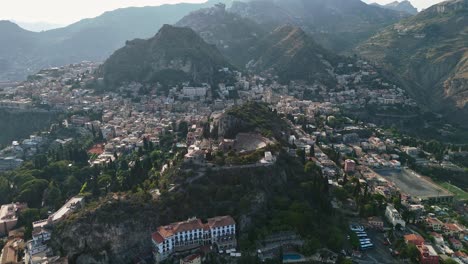 Una-Pintoresca-Ciudad-Costera-Situada-Entre-Colinas-Y-Montañas,-Vista-Aérea