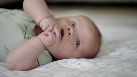 Baby-Caucasian-boy-playing-with-a-colorful-toy-on-a-white-play-mat