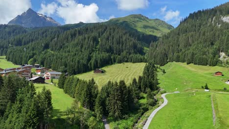 Aufsteigende-Luftaufnahme-Der-Grünen-Berglandschaft-Österreichs-Mit-Kleinem-Dorf