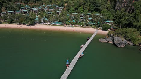 Forward-moving-drone-view-of-a-wooden-pathway-on-Pai-Plong-Beach-during-daytime-in-Krabi,-Thailand