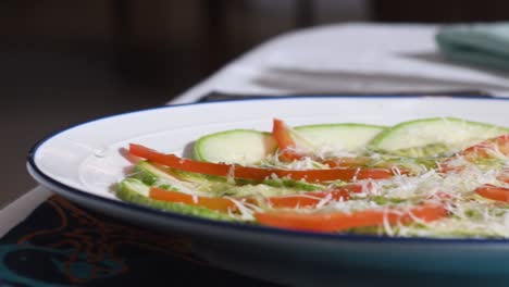 Carpaccio-De-Calabacín-Crudo-Cortado-En-Rodajas-Finas-Rociado-Con-Jugo-De-Limón,-Pimientos-Y-Aceite-De-Oliva.