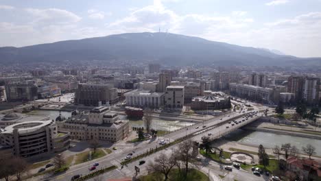 Vista-Aérea-De-Skopje,-Que-Muestra-La-Bandera-De-Macedonia-Y-El-Paisaje-Urbano-De-La-Ciudad.