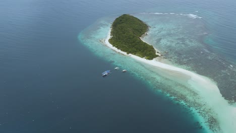 Drone-shot-of-a-tropical-island-in-the-Philippines-surrounded-by-crystal-clear-waters-landscape-shot