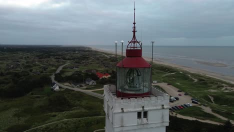 Close-up-drone-shot-circling-clockwise-around-the-top-of-Blåvand-Lighthouse-with-beacon-off