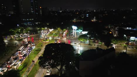 Night-city-street-aerial-approaches-bright-street-intersection-traffic