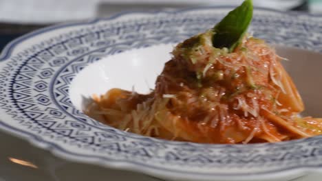 Close-up-Red-sauce-pasta,-table-set-Mediterranean-style-italian-food,-pan-left