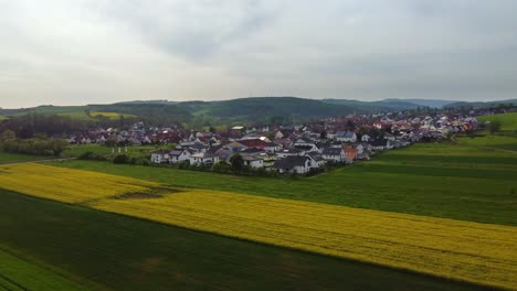 Ländliches-Leben-In-Einem-Kleinen-Deutschen-Dorf-Inmitten-Einer-Grünen-Ländlichen-Landschaft,-Drohne-Vorwärts