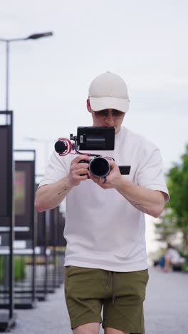 Vertical---videographer-with-digital-camera-equipment-walk-outdoor,-Czechia