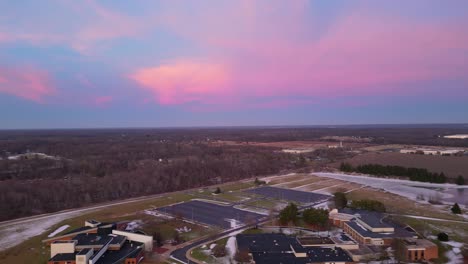 Aerial-view-capturing-a-vivid-sunset-over-a-rural-landscape,-highlighting-the-colorful-sky-and-serene-surroundings,-ideal-for-nature-and-travel-visuals