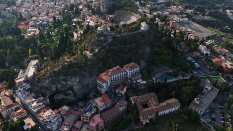 Un-Pintoresco-Pueblo-Mediterráneo-Enclavado-En-Colinas-Rodeado-De-Vegetación,-Vista-Aérea