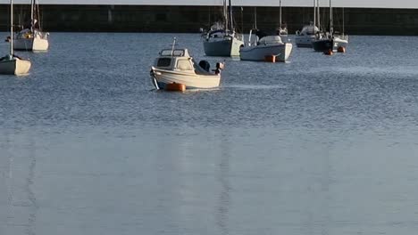 Viele-Segelboote-Und-Yachten-Schwimmen-Auf-Dem-Ruhigen-Meereshafen-Und-Spiegeln-Sich-Im-Warmen-Sonnenaufgang