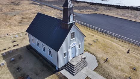 Luftaufnahme-Der-Strandarkirkja-Kirche-An-Islands-Südküste-Mit-Malerischem-Meerblick-Und-Umliegender-Landschaft