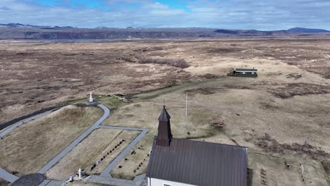 Strandarkirkja-church-and-graveyard-with-breathtaking-aerial-coastal-view-of-Iceland's-unique-landscape-and-ocean-waves