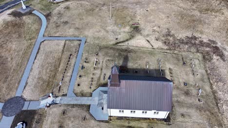 Kleine-Kirche-Auf-Einem-Hügel-Mit-Blick-Auf-Den-Weiten-Ozean-Mit-Friedlichem-Friedhof-Und-Gepflastertem-Weg,-Der-Zu-Einer-Heiteren-Atmosphäre-Führt