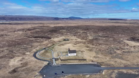 Vista-Aérea-De-La-Iglesia-De-Strandarkirkja,-Que-Muestra-La-Costa-única-Y-Accidentada-De-Islandia