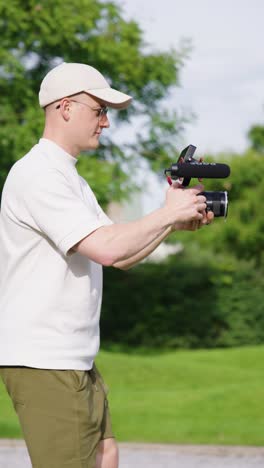 Vertical-view-of-professional-filmmaker-perform-handheld-technique-with-camera