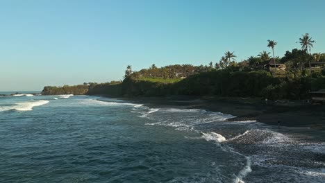 Waves-dance-in-rhythmic-symphony,-tropical-paradise-vegetation,-aerial