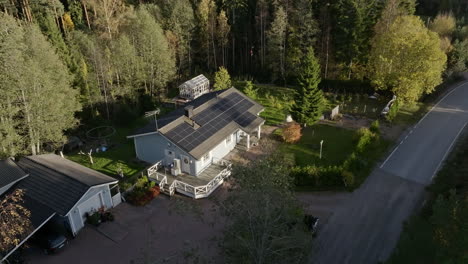 Vista-Aérea-Desde-Detrás-De-Un-árbol,-Alrededor-De-Una-Casa-Alimentada-Con-Energía-Solar,-Día-Soleado-De-Otoño