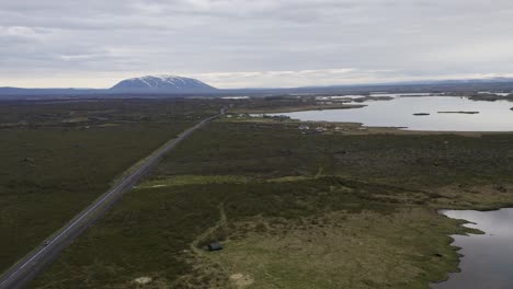 Aerial-approaching-shot-of-cars-on-island-highway-beside-Myvatn-Lake-in-Iceland