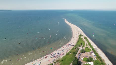 Big-water-sports-event-in-Poland,-with-long-sandy-beach,-busy-with-windsurfers-and-kitesurfers