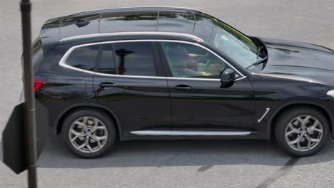 Tracking-shot-of-modern-BMW-Suv-car-on-street-in-american-neighborhood